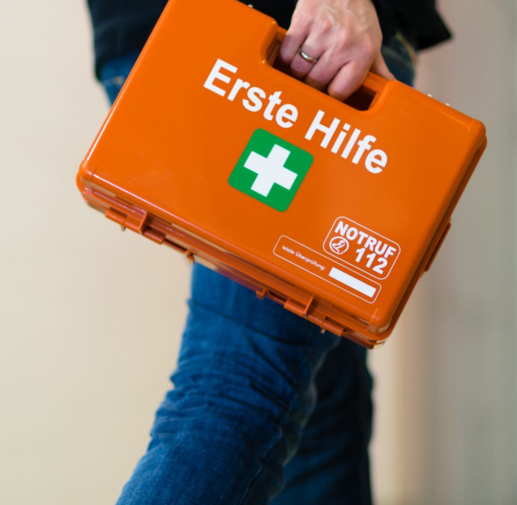 Man with first aid kit runs to help. A german first aid kit